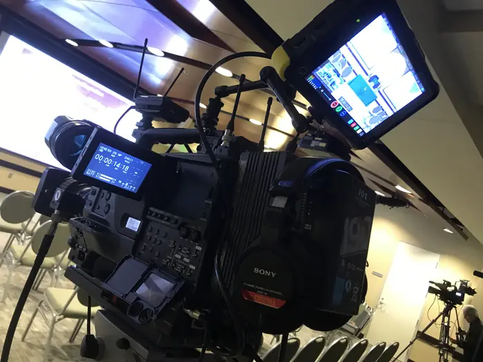 A broadcast camera rig with a monitor on location